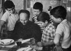 13x18-O-Don-Milani-e-ragazzi-al-tavolo-1.jpg